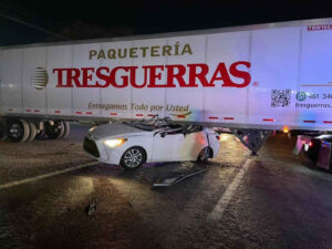 ROJA AUTO QUEDO BAJO UN TRAILER