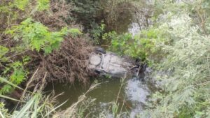 ROJA AUTO AL FONDO DE LA PRESA